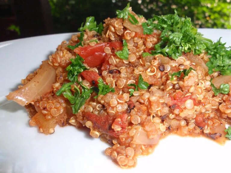 Close up view of mexican quinoa with tomatoes, onions and fresh herbs, on a white plate