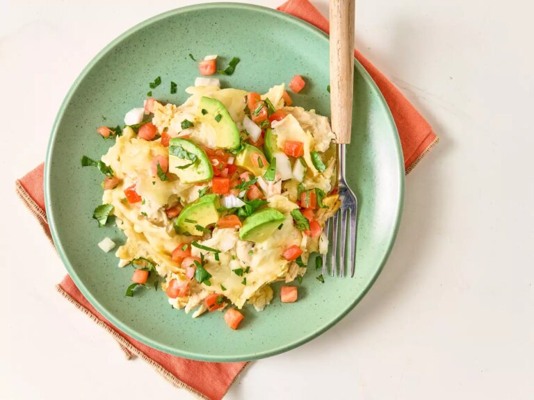 Overhead view of crockpot chicken enchilada casserole on green plate