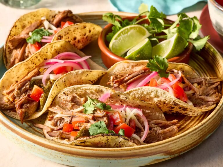Slow cooker brisket tacos with toppings on a platter garnished with cilantro