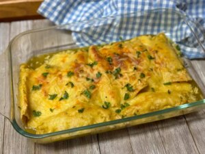 Glass casserole dish of ham, egg, and cheese enchiladas