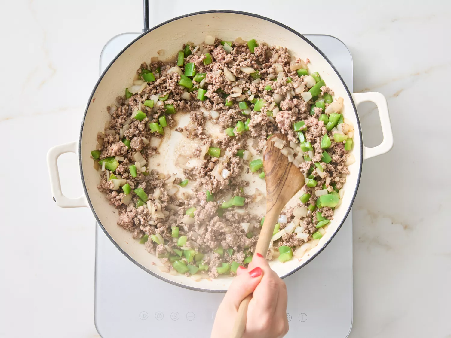 Ground meat and vegetables being sautéed in a pot