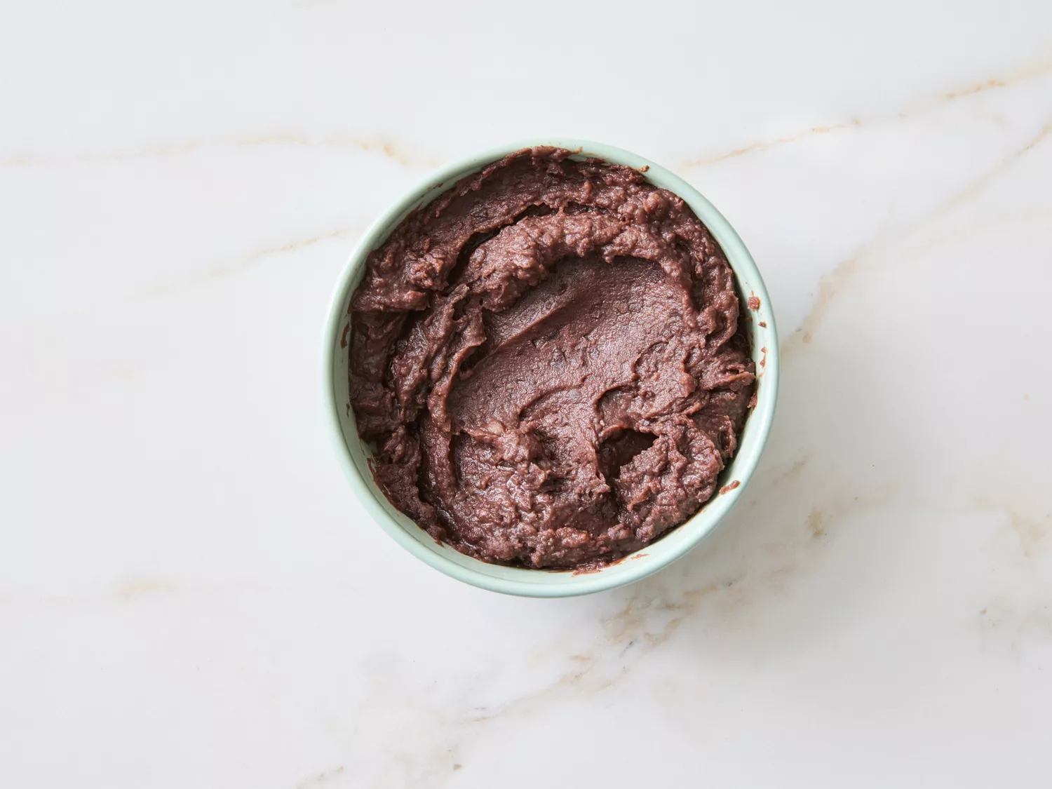 Bowl of a dark, thick food mixture, possibly a step in a recipe
