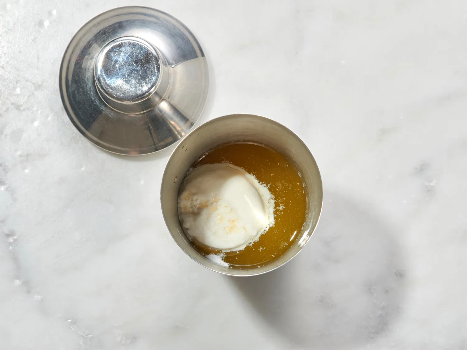 Cocktail shaker with ingredients to make a drink, ice cream visible inside