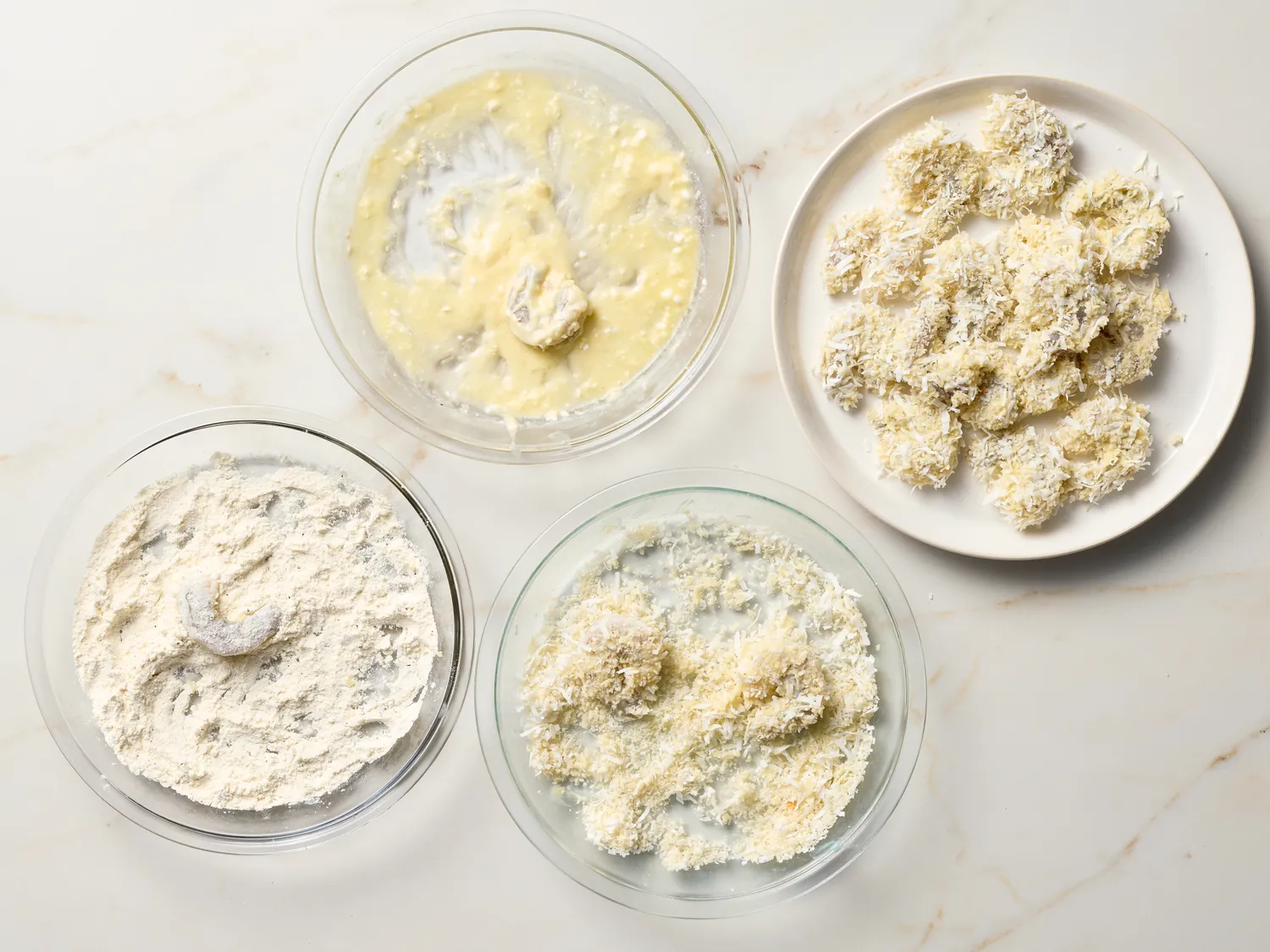 Preparation steps for coconut shrimp shown in separate dishes