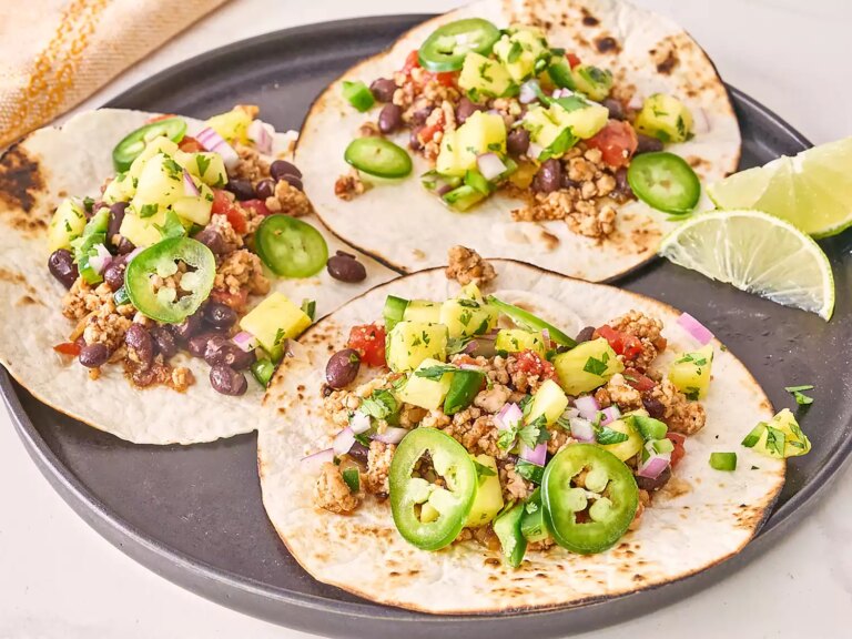 3 pork tacos on grey plate with pineapple salsa