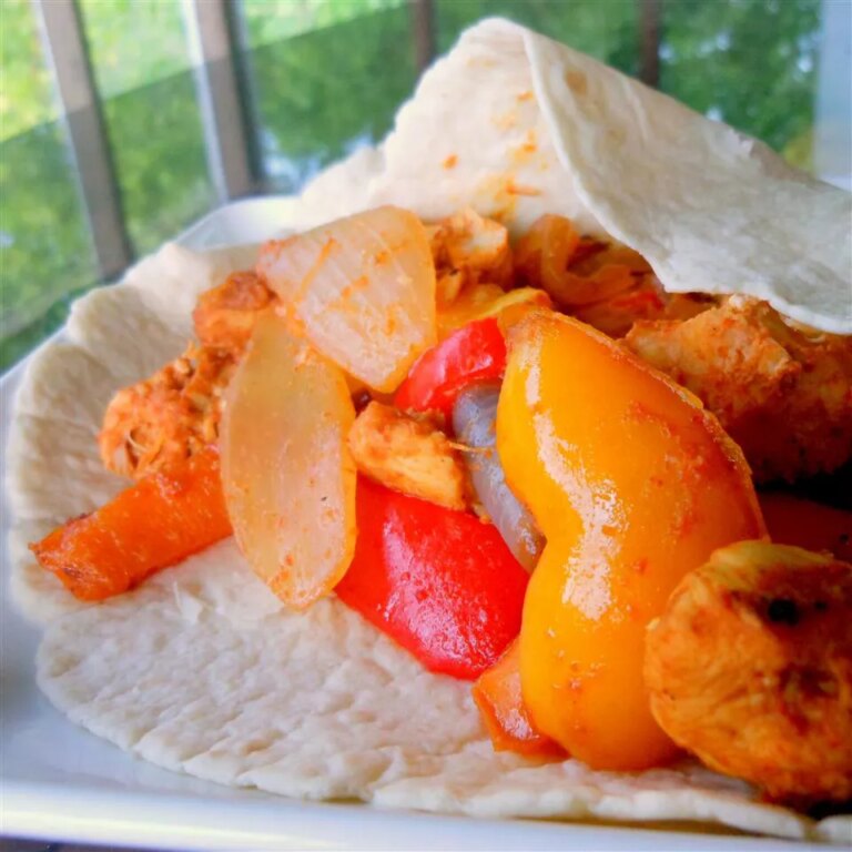 Close up view of pollo fajitas with peppers on a tortilla