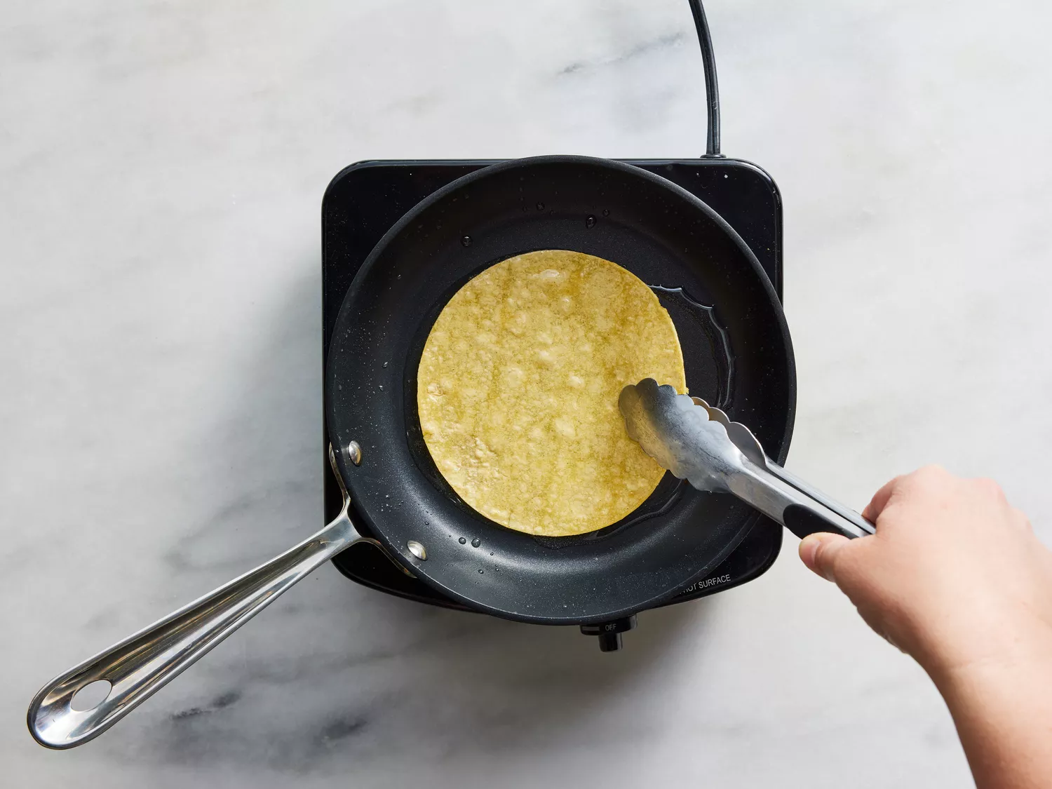 tortillas being fried in oil to soften each side.
