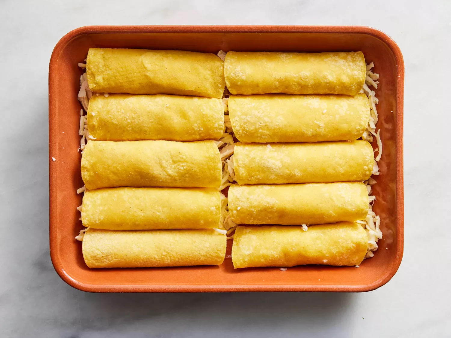 tortillas roll up and placed seam-side down in the prepared dish.