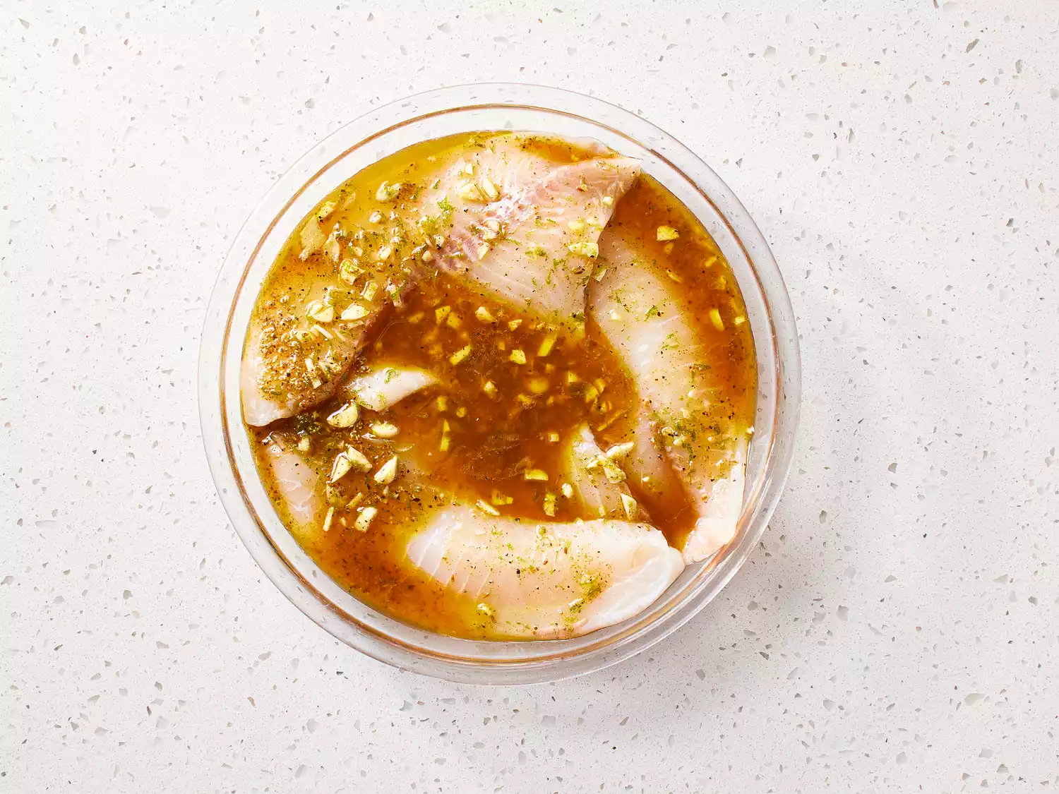 Fish fillets and marinade in a glass bowl 