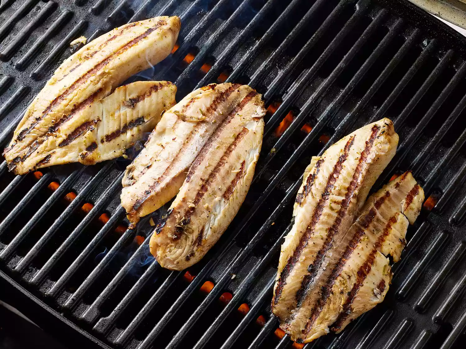 Tilapia fillets cooking on a grill 
