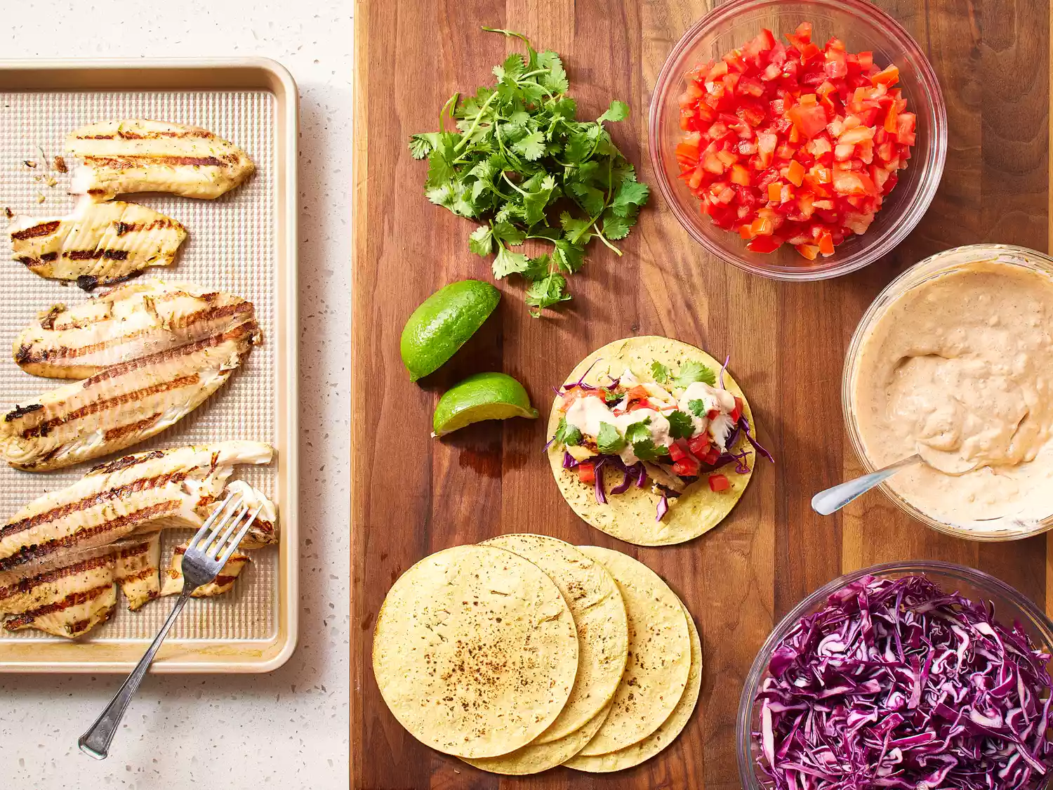 Grilled Fish Tacos with Chipotle-Lime Dressing assembled on a wooden cutting board 