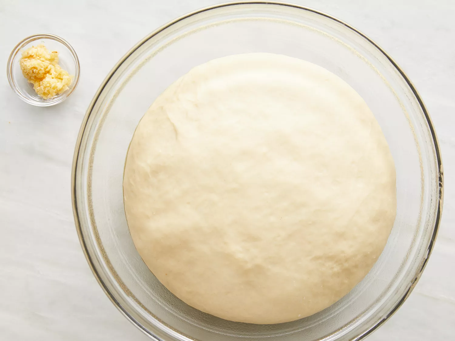 Overhead shot of naan dough rising in a bowl