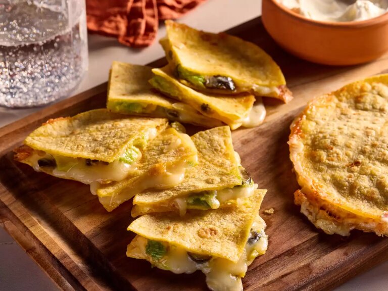 Golden, crispy quesadilla slices with melted cheese on a wooden board