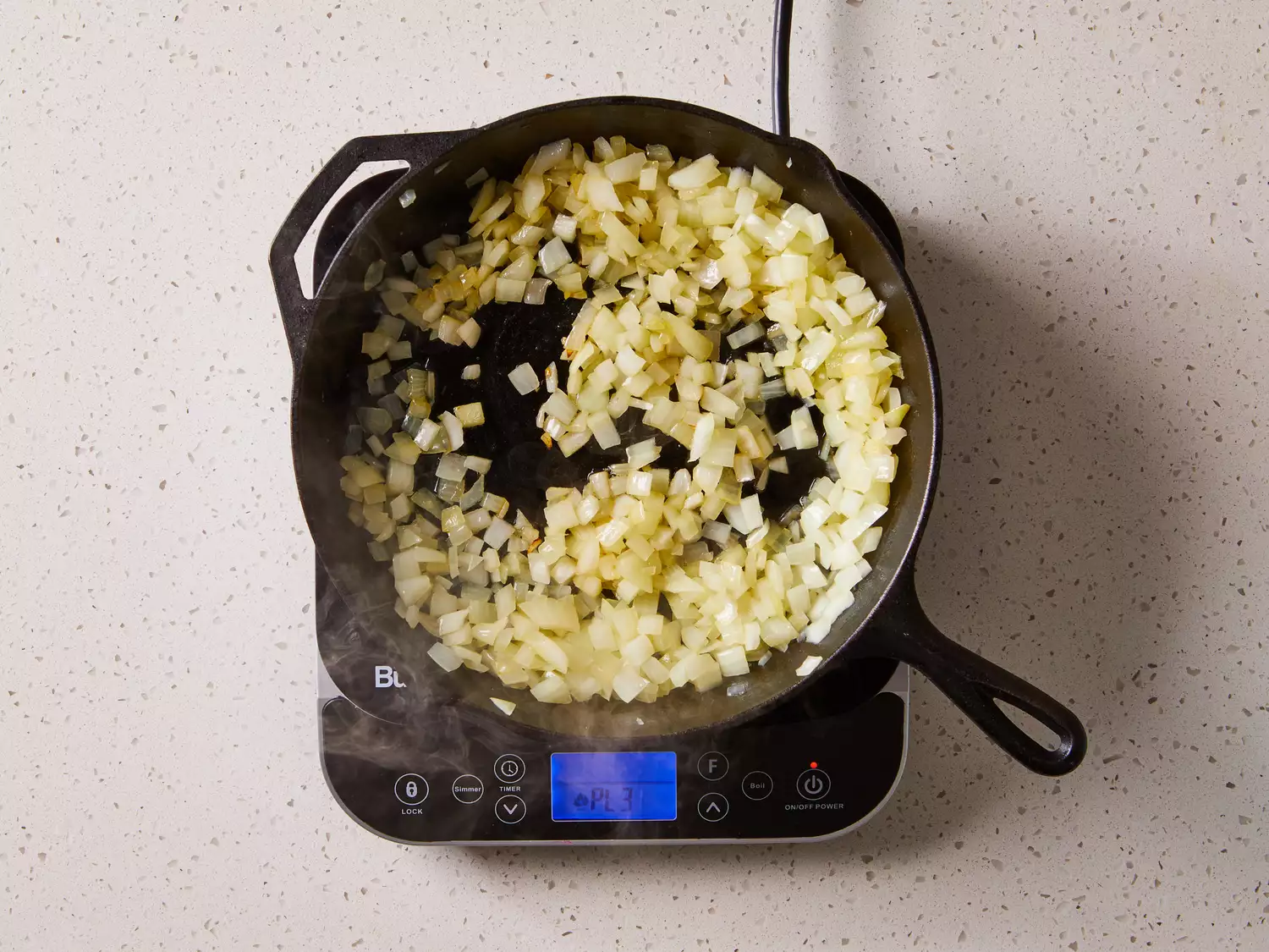 Onions cooking in a cast iron skillet on a burner 