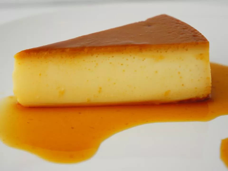 Close up view of a slice of quesillo (venezuelan flan) on a white plate