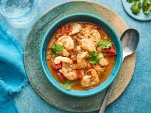 Looking down at a bowl of spicy fish soup, garnished with cilantro.