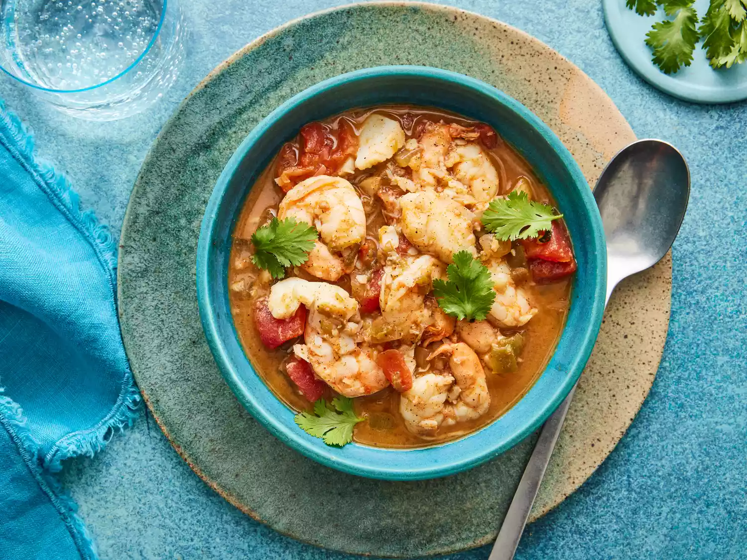 Looking down at a bowl of spicy fish soup, garnished with cilantro.