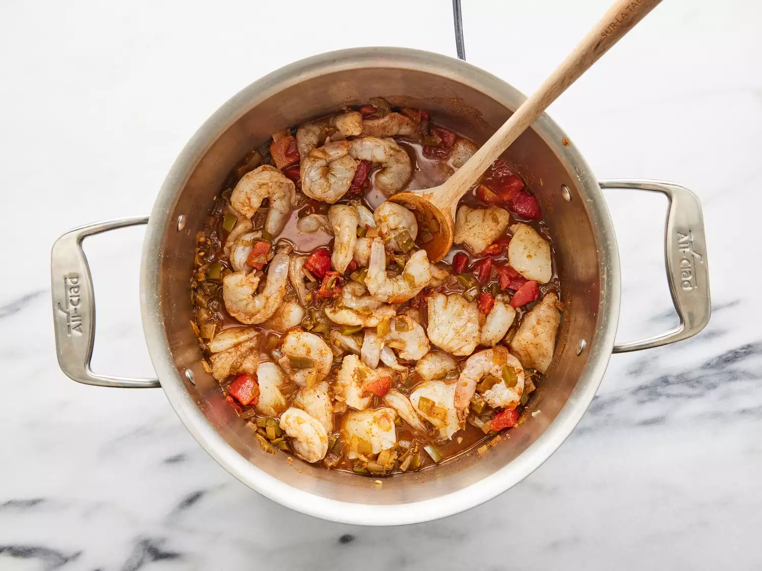 tomatoes, bell pepper, shrimp and cod added to pot, covering and left to simmer.