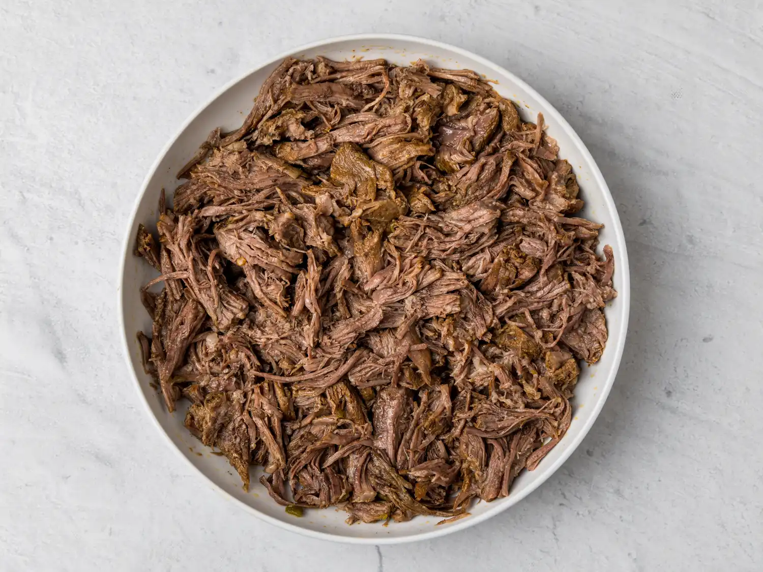 A bowl filled with shredded meat prepared Mexicanstyle
