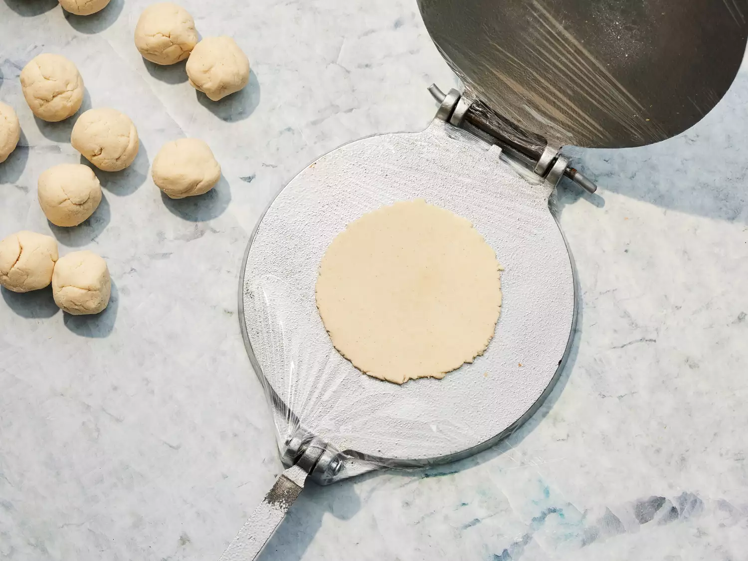 dough divided into balls and flattened with a tortilla press.