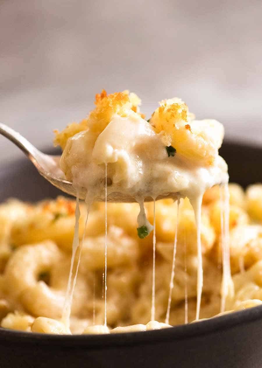 Baked Mac and Cheese Recipe Spoon lifting up a scoop of cheesy Macaroni Cheese