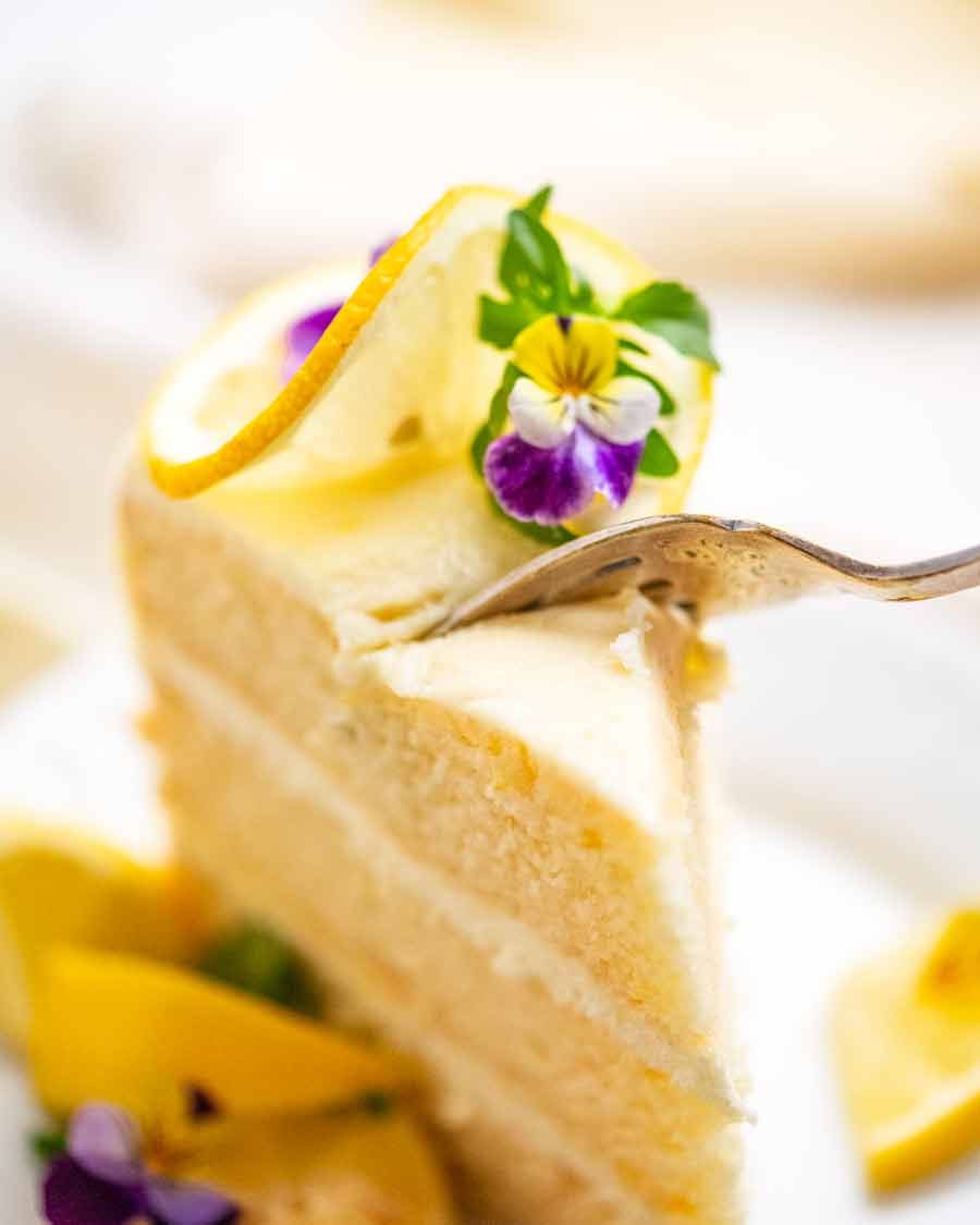 Lemon Cake with Fluffy, Less-Sweet Lemon Frosting Recipe Fork cutting into piece of Lemon Cake with Fluffy Lemon Frosting