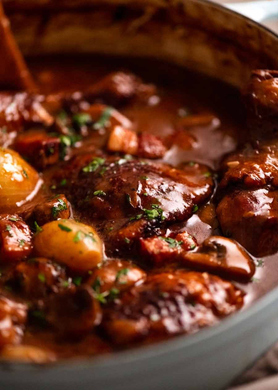 Coq au Vin Recipe Close up photo of Coq au Vin - French chicken stew in a pot, fresh off the stove