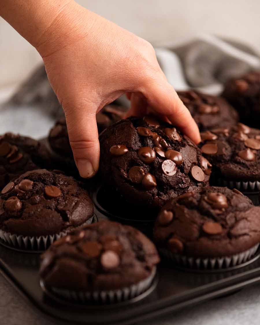 Chocolate Muffins Recipe Hand reaching for Chocolate Muffins