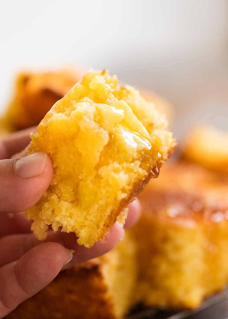 Cornbread recipe Hand holding piece of Cornbread, showing the inside of Cornbread