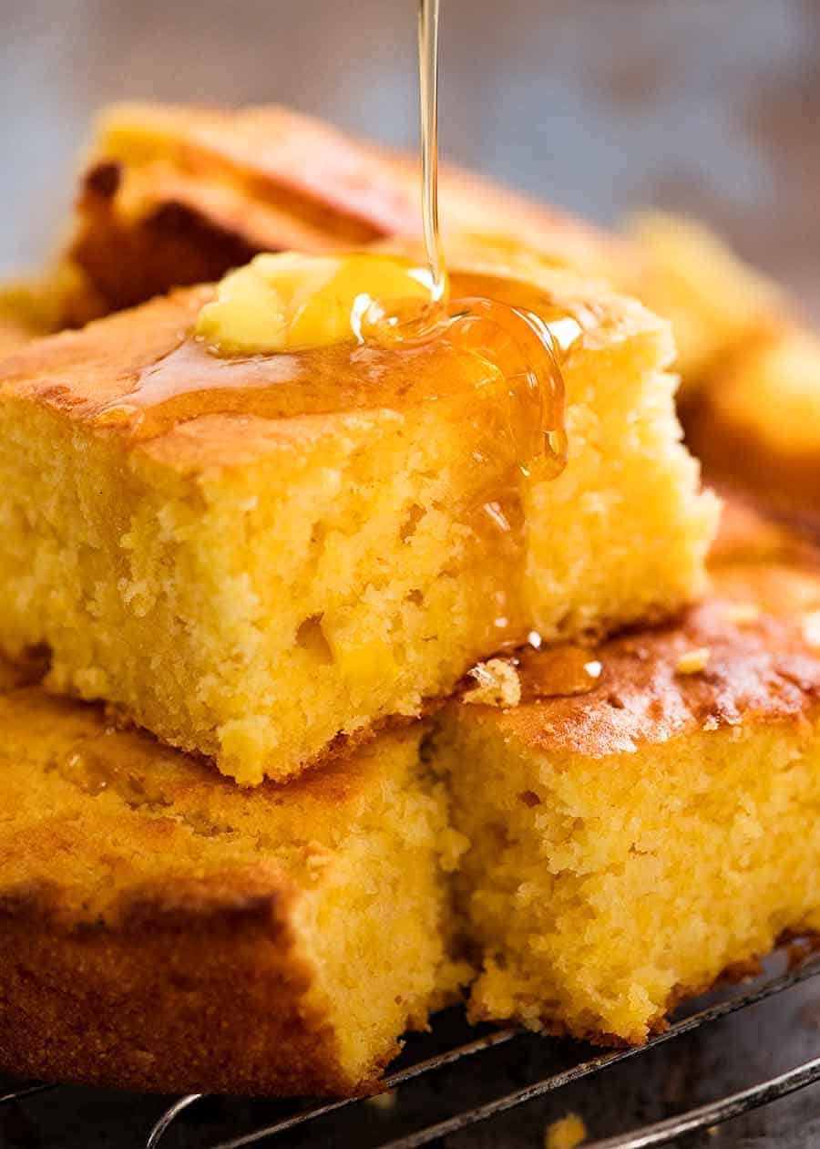 Cornbread recipe Honey being drizzled on a piece of Cornbread