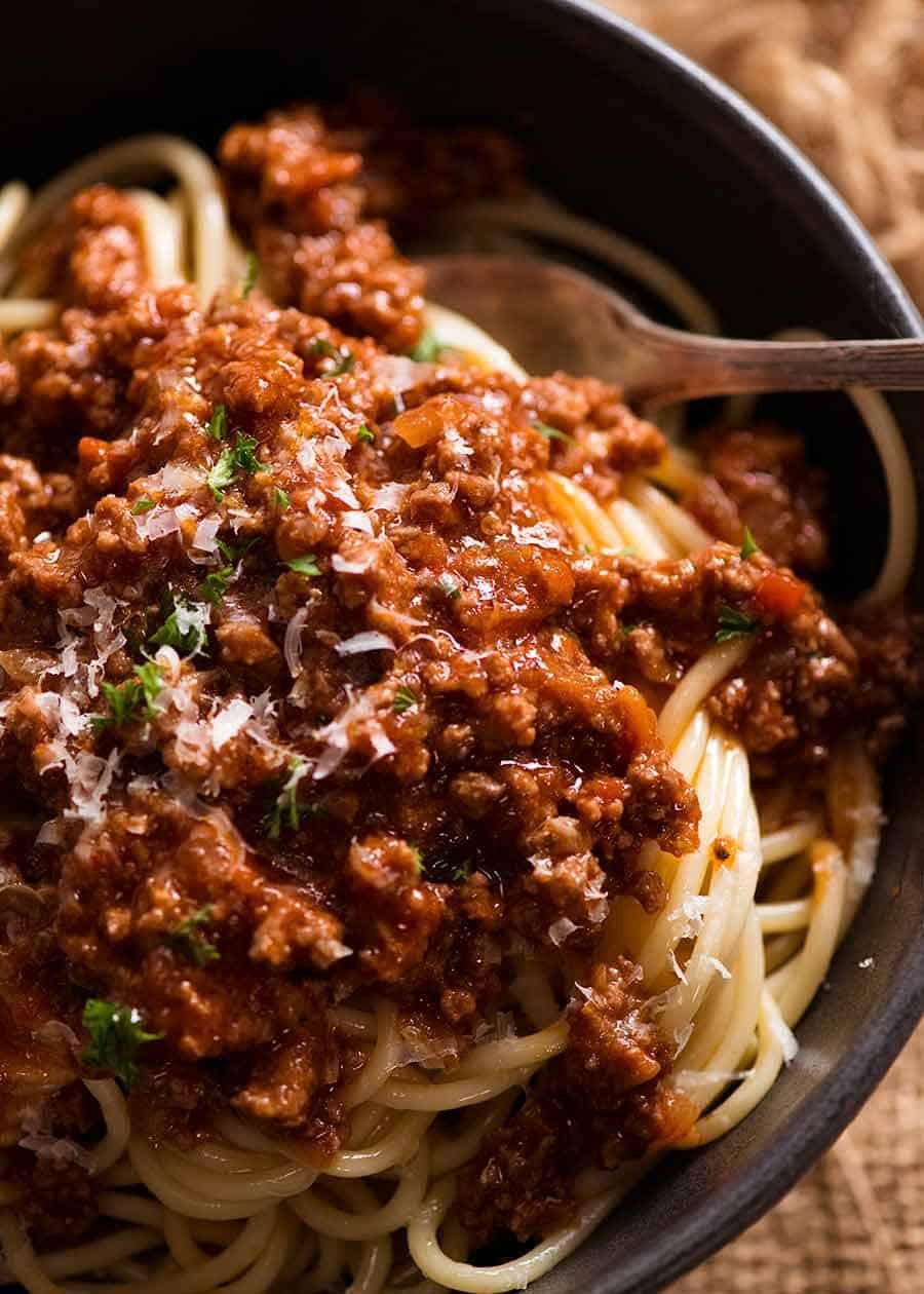 Spaghetti Bolognese Recipe Close up of Spaghetti Bolgonese in a rustic black bowl, ready to be eaten