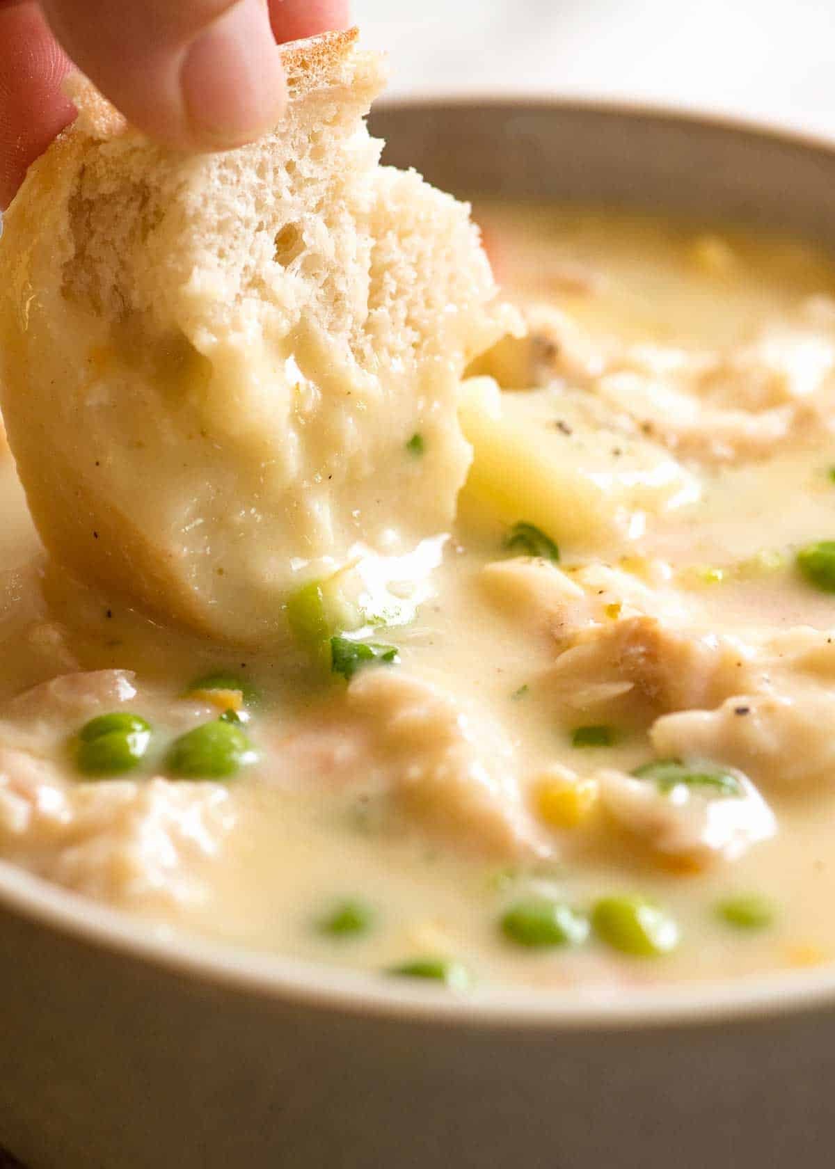 Fish Chowder Soup Recipe Bread being dunked into Fish Chowder Soup