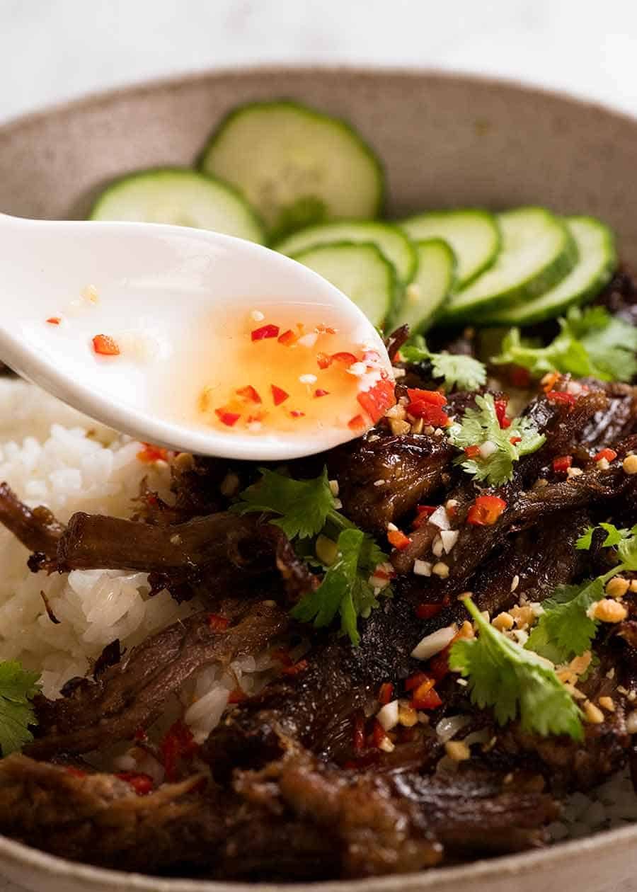 Caramelised Vietnamese Shredded Beef Recipe Nuoc Cham sauce being drizzled over Caramelised Vietnamese Shredded Beef