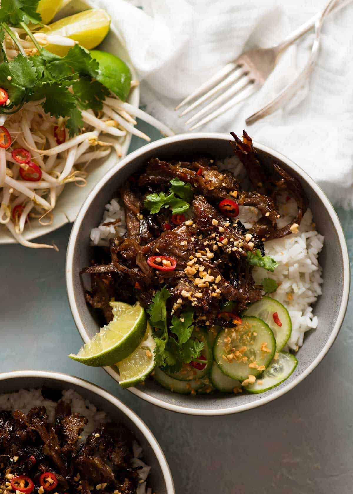 Caramelised Vietnamese Shredded Beef Recipe 2 bowls of Caramelised Vietnamese Shredded Beef over rice with a side of bean sprouts and fresh herbs