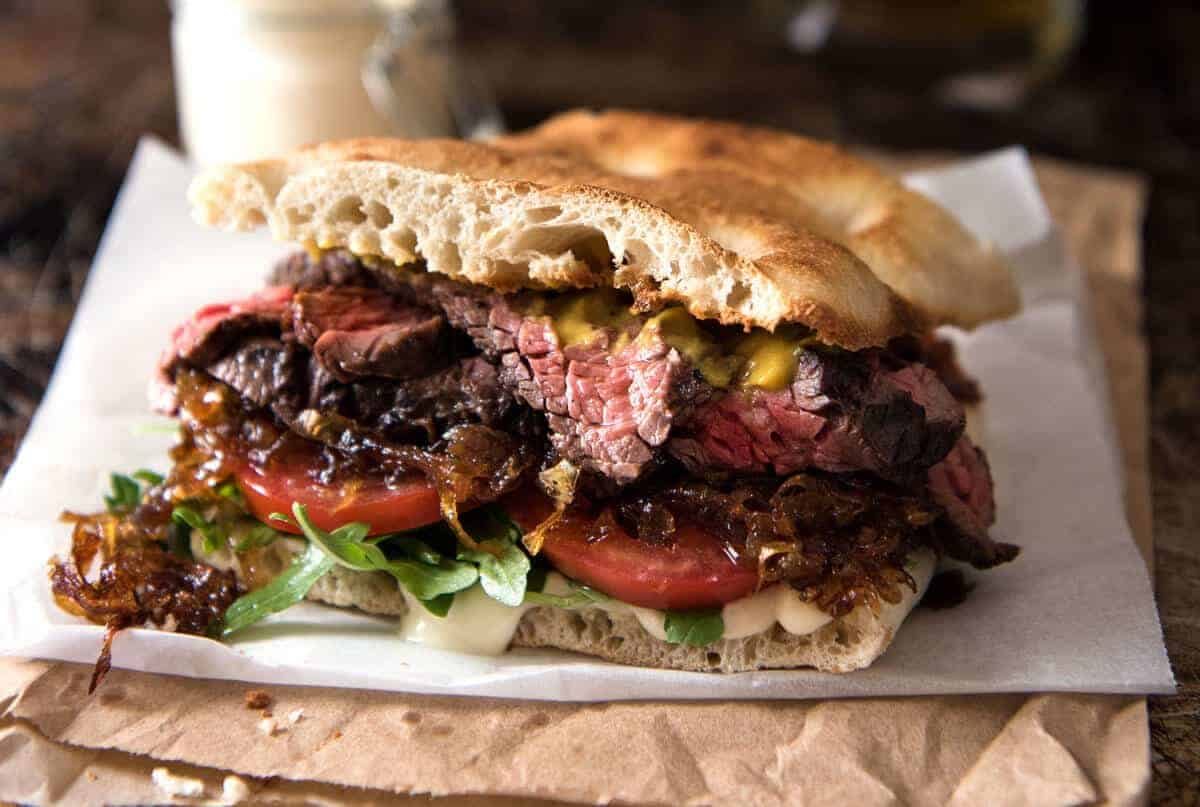 Steak Sandwich Recipe A juicy Steak Sandwich loaded with tender slices of steak, caramelised onion, garlic aioli, lettuce, tomato and mustard. www.recipetineats.com