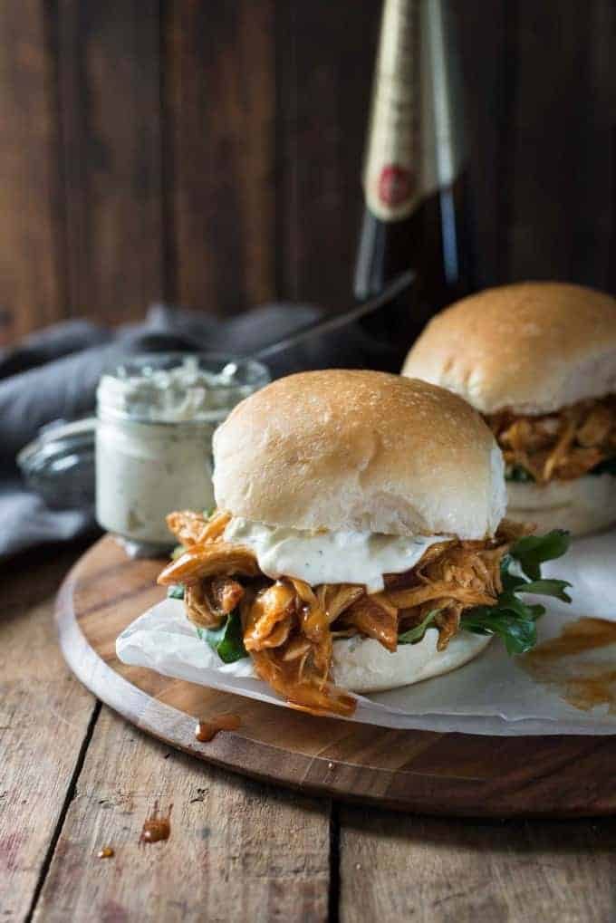 Slow Cooker Honey Buffalo Chicken Sliders on a platter with beer
