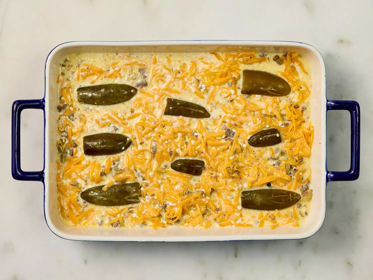 Jalapeño casserole with cheese and egg mixture before baking.