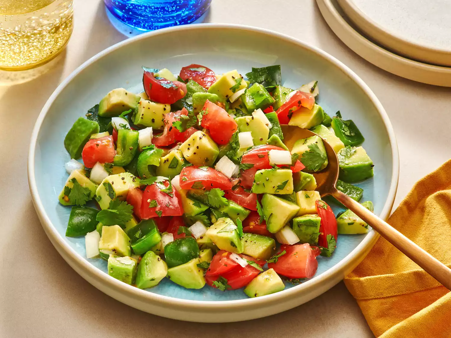 Avocado salad on a platter with a spoon