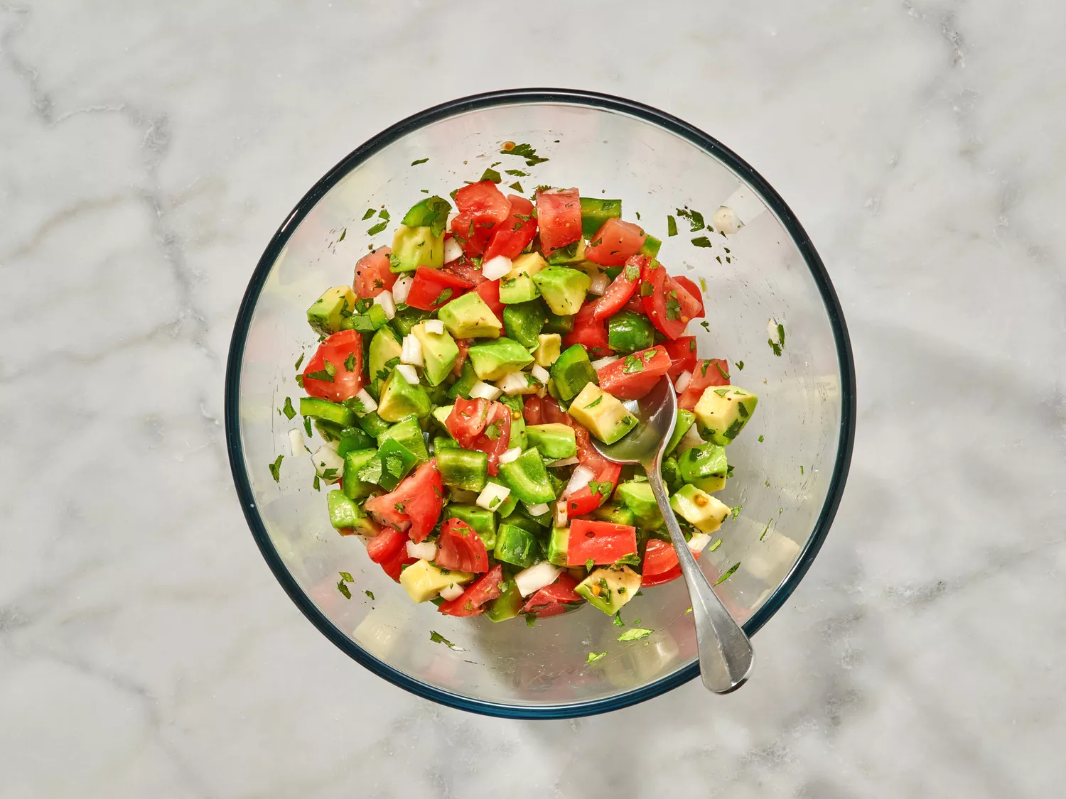 Avocado Salad in a glass bowl with a spoon 