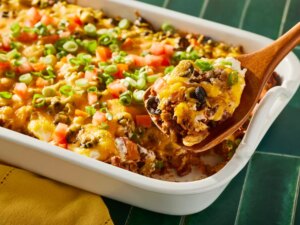 A serving of mexican casserole being scooped out of the baking dish