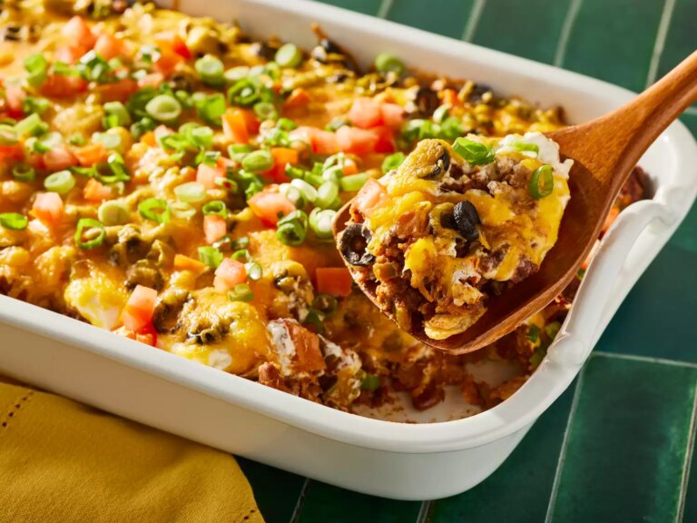 A serving of mexican casserole being scooped out of the baking dish