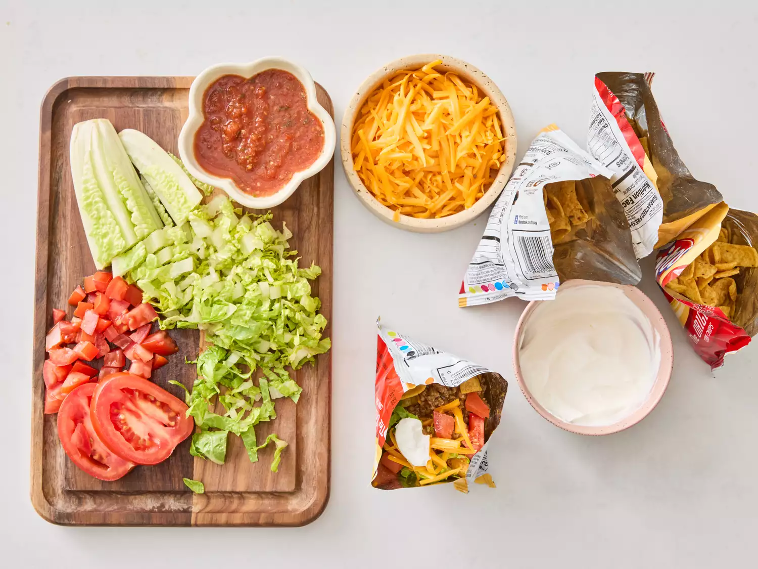 Prepared ingredients and Tacos in a bag on white surface