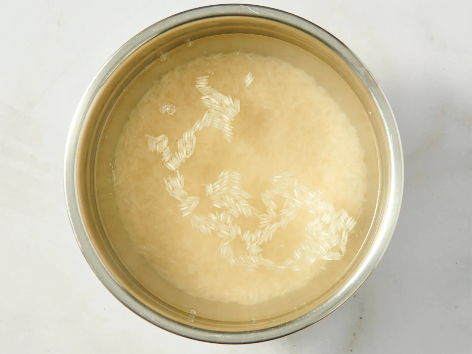 Uncooked rice soaking in a bowl of water