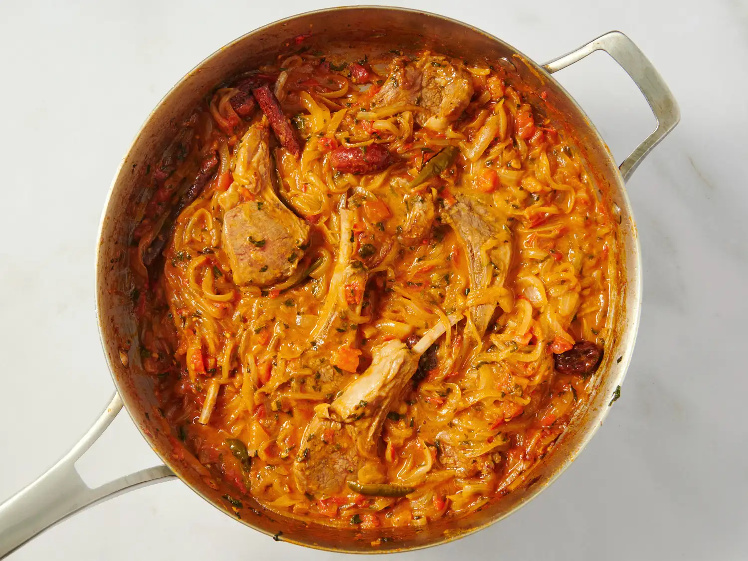 A pot filled with lamb gosht biryani a cooked dish featuring rice spices and chunks of meat