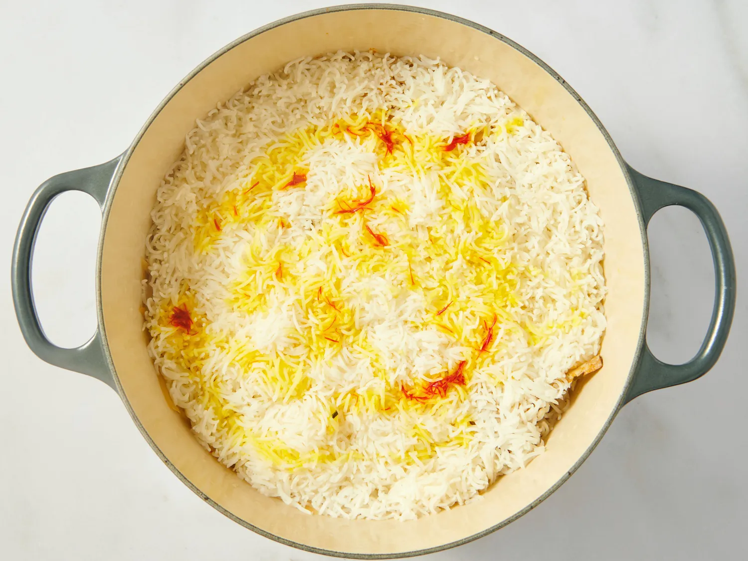 Cooked rice with saffron in a large pot with handles