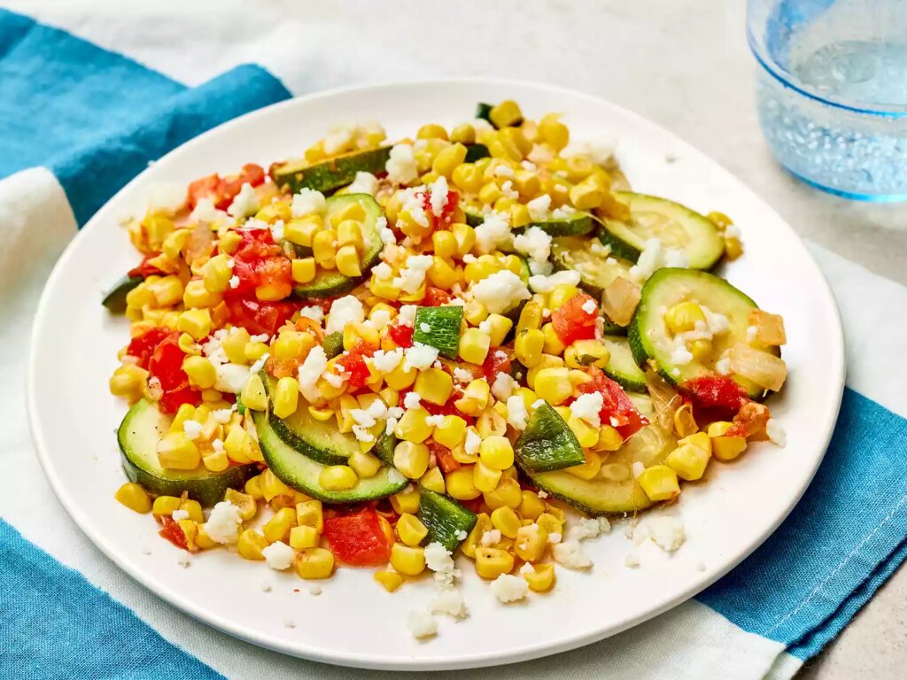 Calabacitas con elote (zucchini with corn) on a white plate
