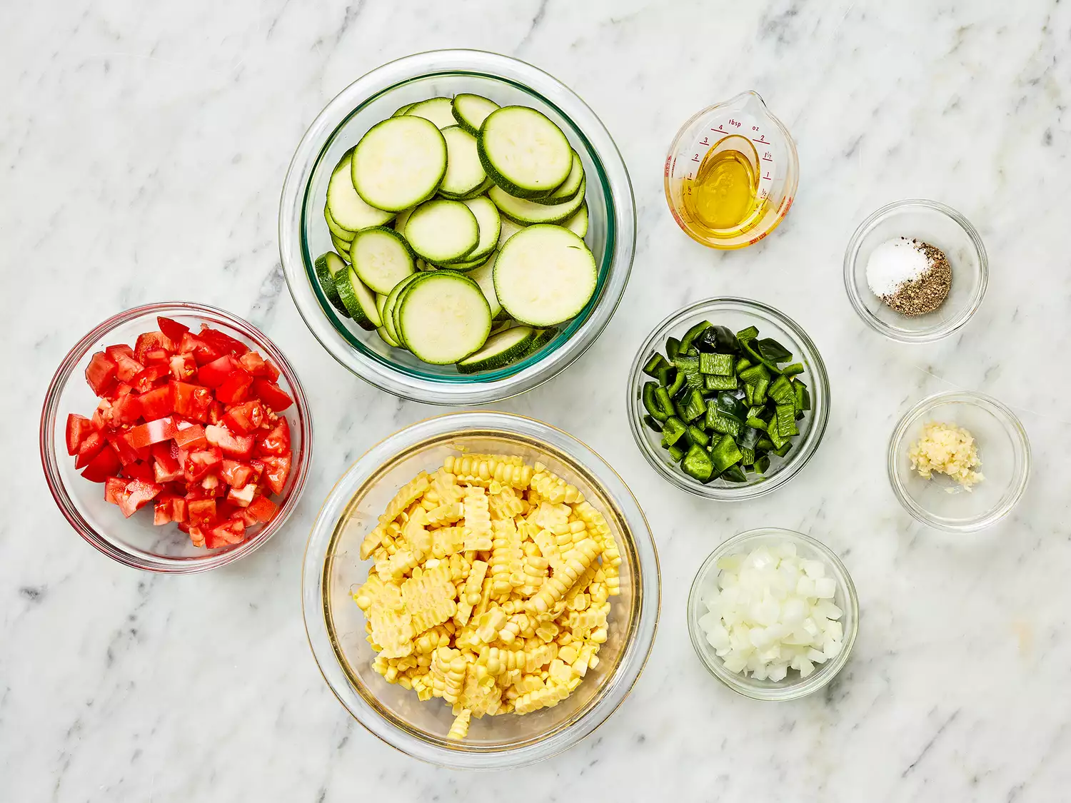 Calabacitas con Elote (Zucchini with Corn) ingredients in glass bowls 