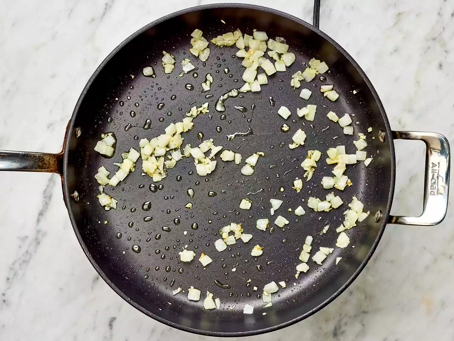 Onions cooking in a pan on a burner 