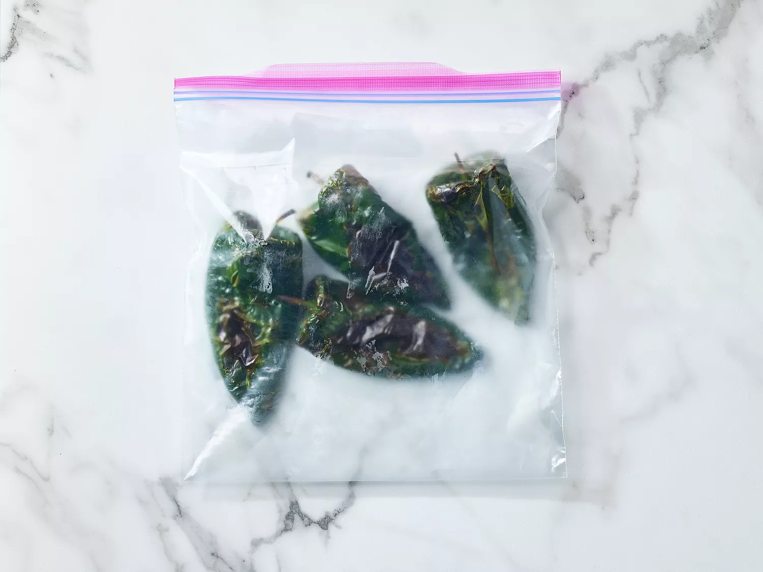 Roasted poblano peppers in a zippered plastic storage bag
