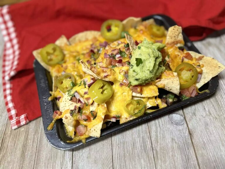 Cheese nachos topped with jalapenos and guacamole